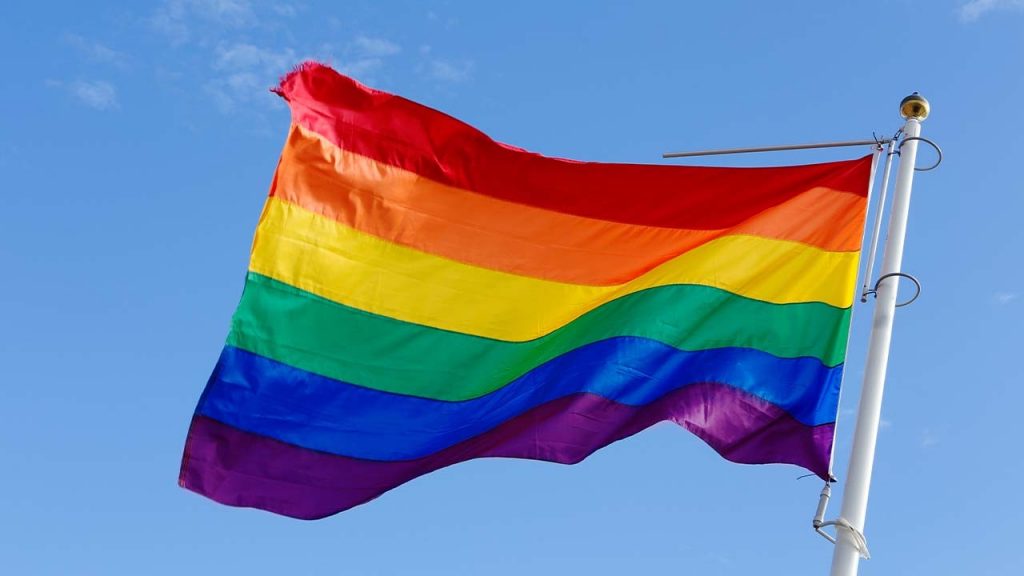 A pride flag flying on a flagpole
