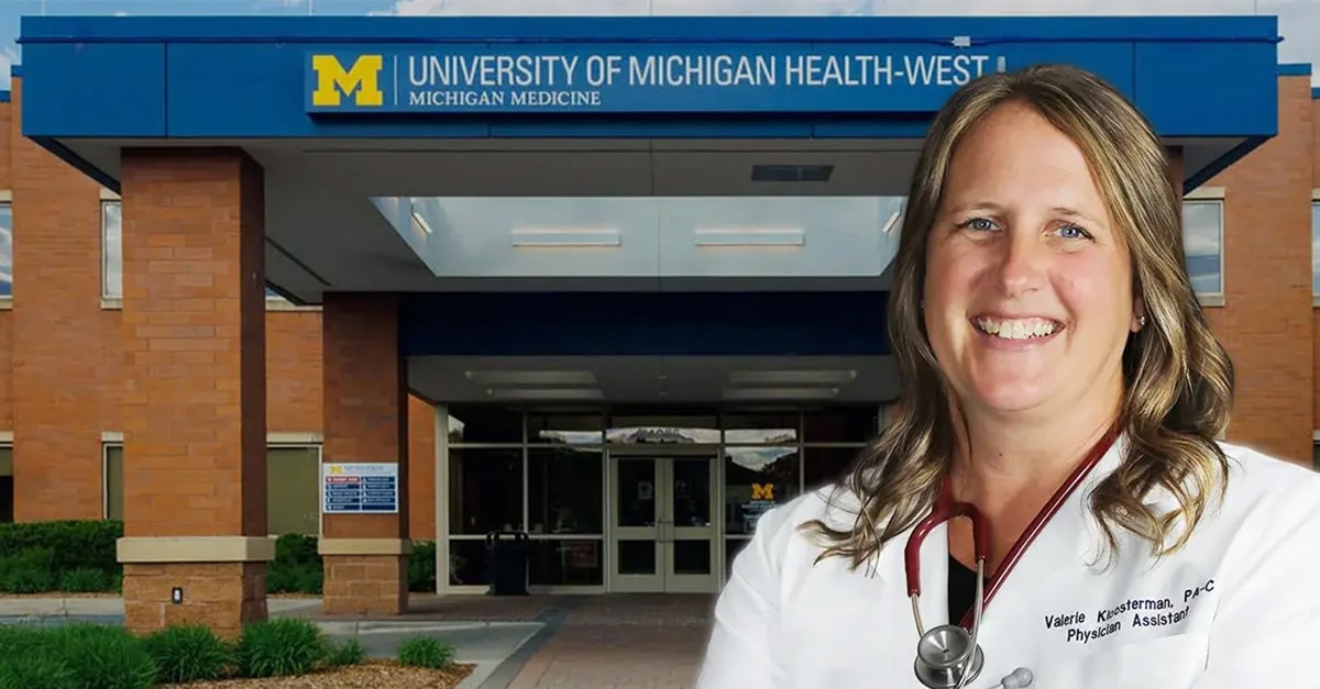 Valerie Kloosterman in her lab coat with stethoscope in front of the entrance to University of Michigan Health-West