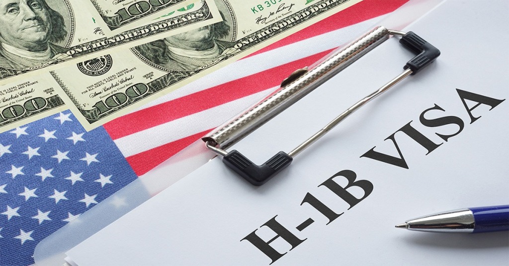 Application for an H-1B Visa is shown along with an American flag and dollar bills.
